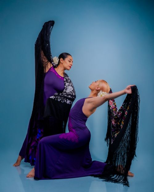Free Two flamenco dancers in vibrant purple dresses gracefully pose against a blue background. Stock Photo