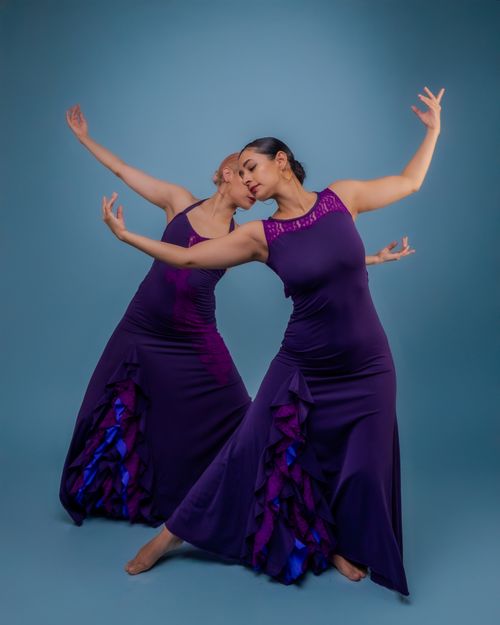 Free Two female dancers gracefully pose in flowing purple dresses, symbolizing unity and elegance. Stock Photo