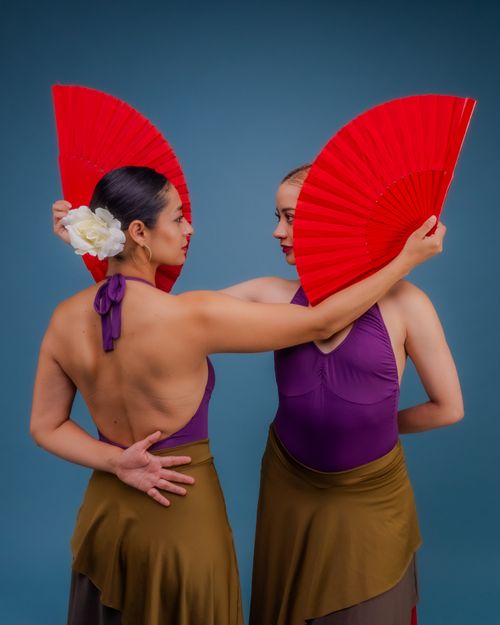 Free Two elegant dancers posing with red fans, showcasing cultural richness and empowerment. Stock Photo
