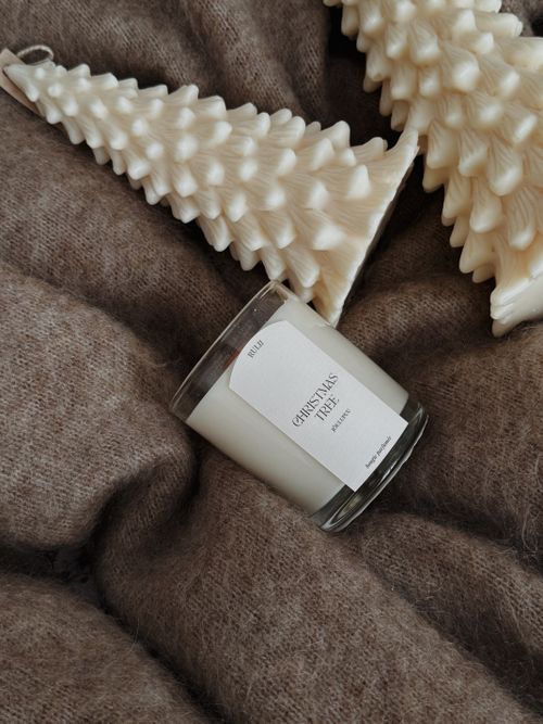 Free Elegant white candle and tree decorations on a soft brown fabric, perfect for the festive season. Stock Photo