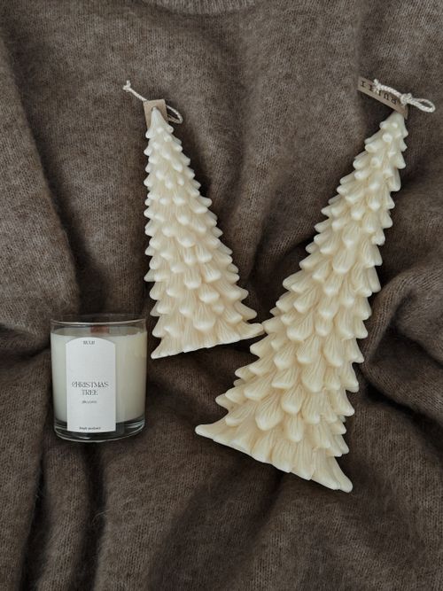 Free Elegant Christmas tree candles and scented candle on soft fabric background. Stock Photo