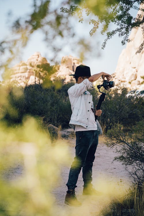grátis Homem Vestindo Jaqueta Branca Segurando Uma Câmera Foto profissional
