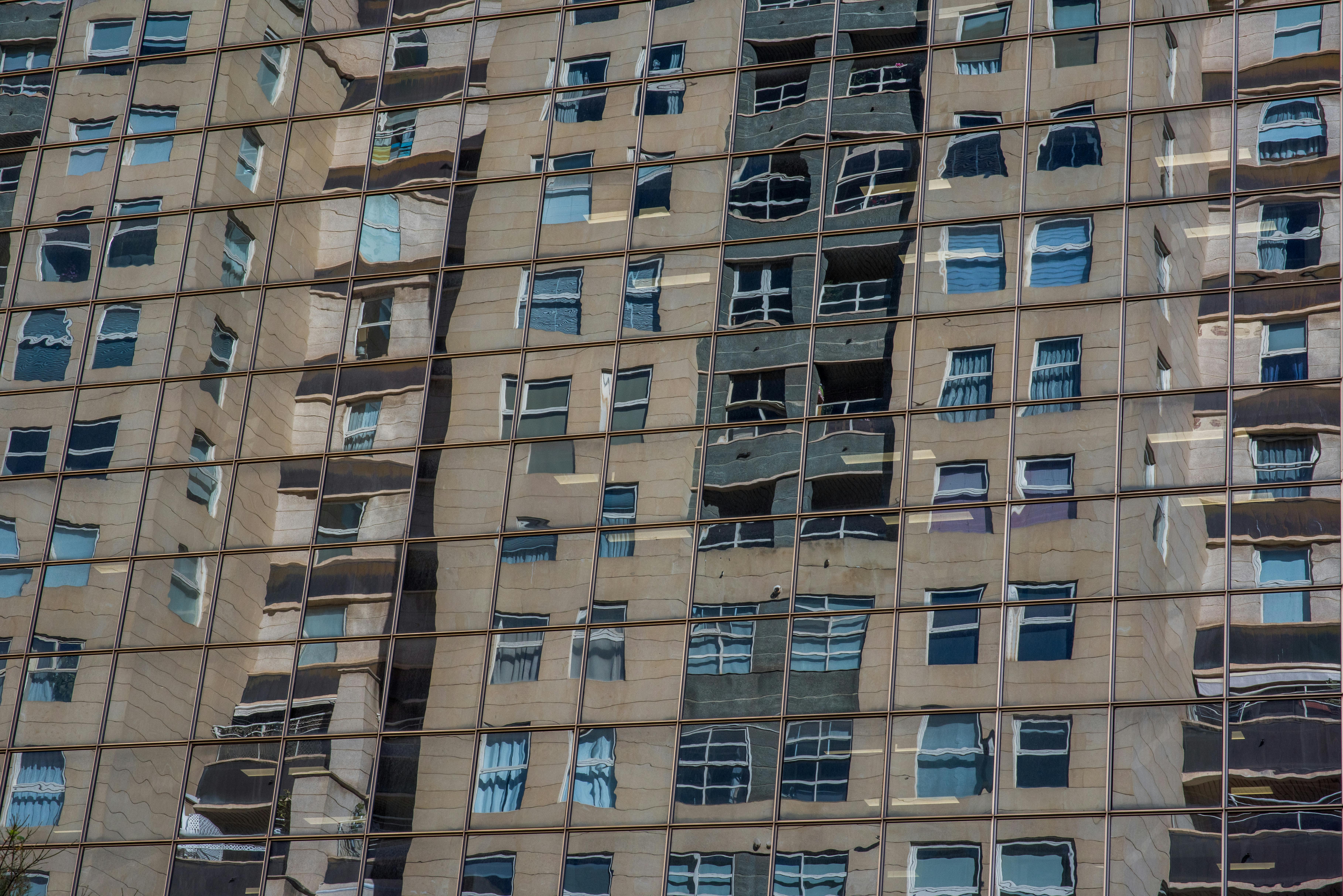 Distorted Building Reflections on Glass Facade · Free Stock Photo
