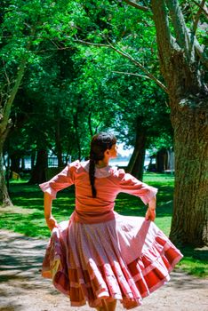 A woman performs a traditional dance in a vibrant forest, embracing cultural heritage.