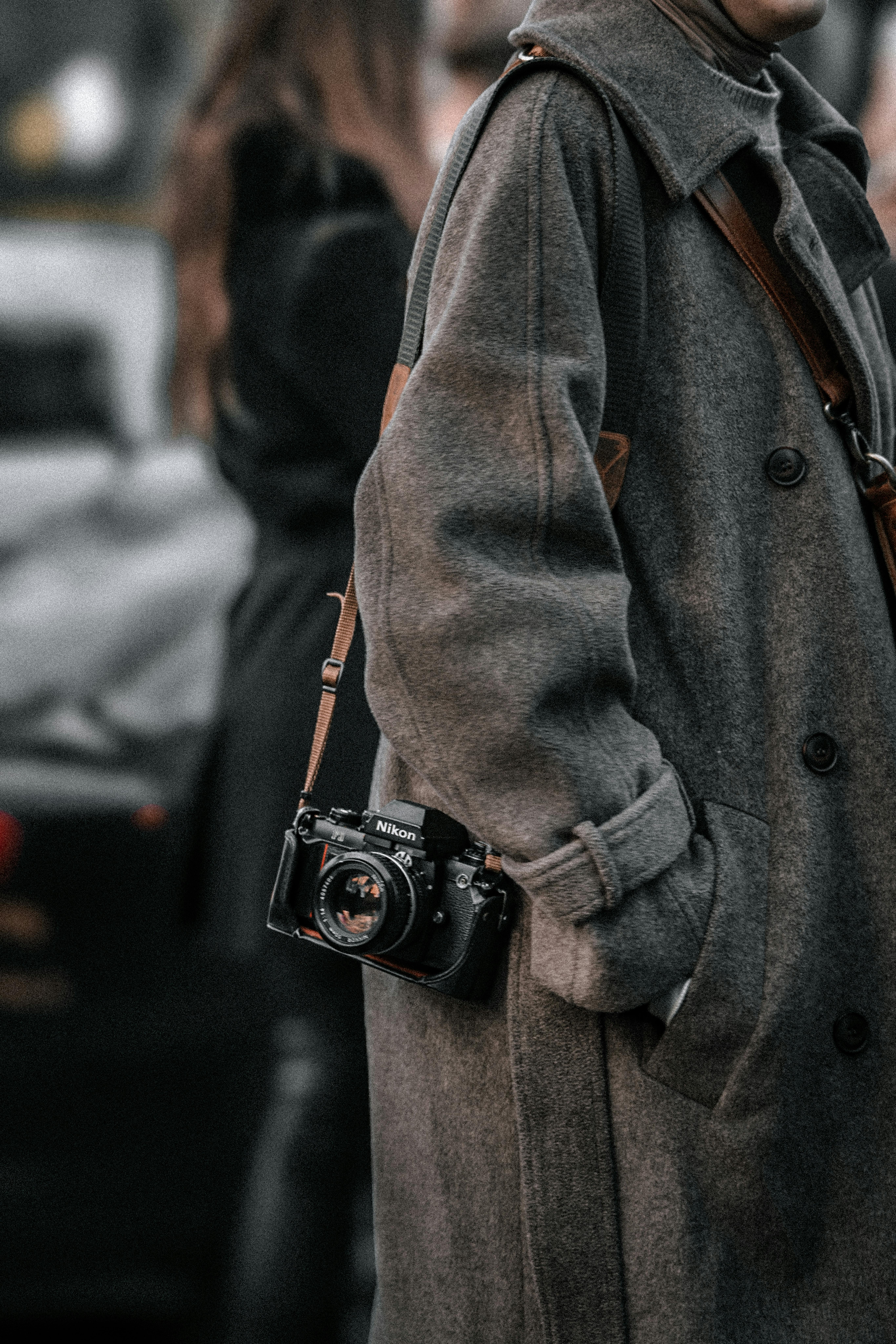vintage camera hanging from brown coat