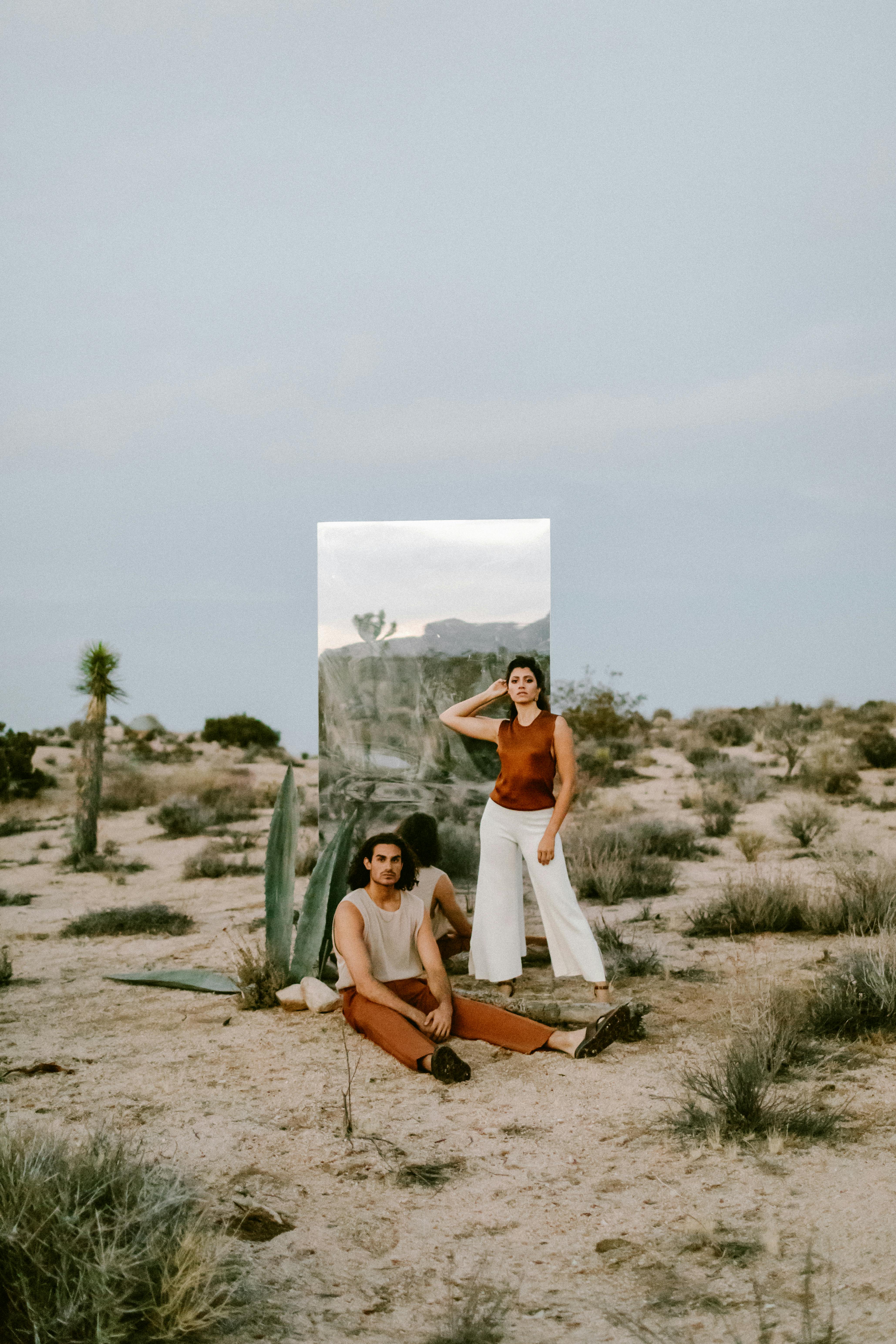 Stylish portrait of models in the Joshua Tree desert with a large mirror.