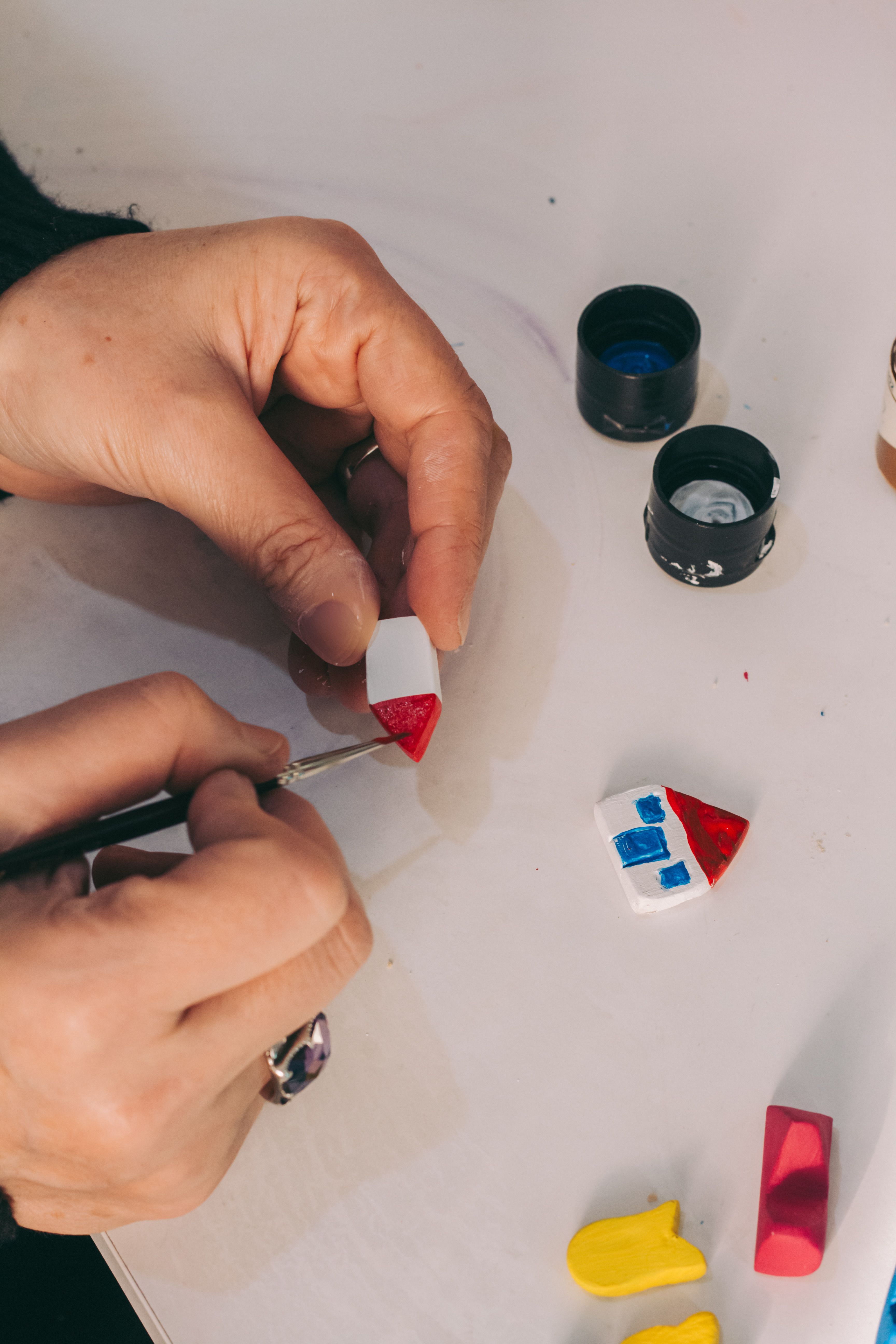 Gratuit Peinture à la main de petites figurines en argile sur une surface blanche avec des détails complexes. Photos
