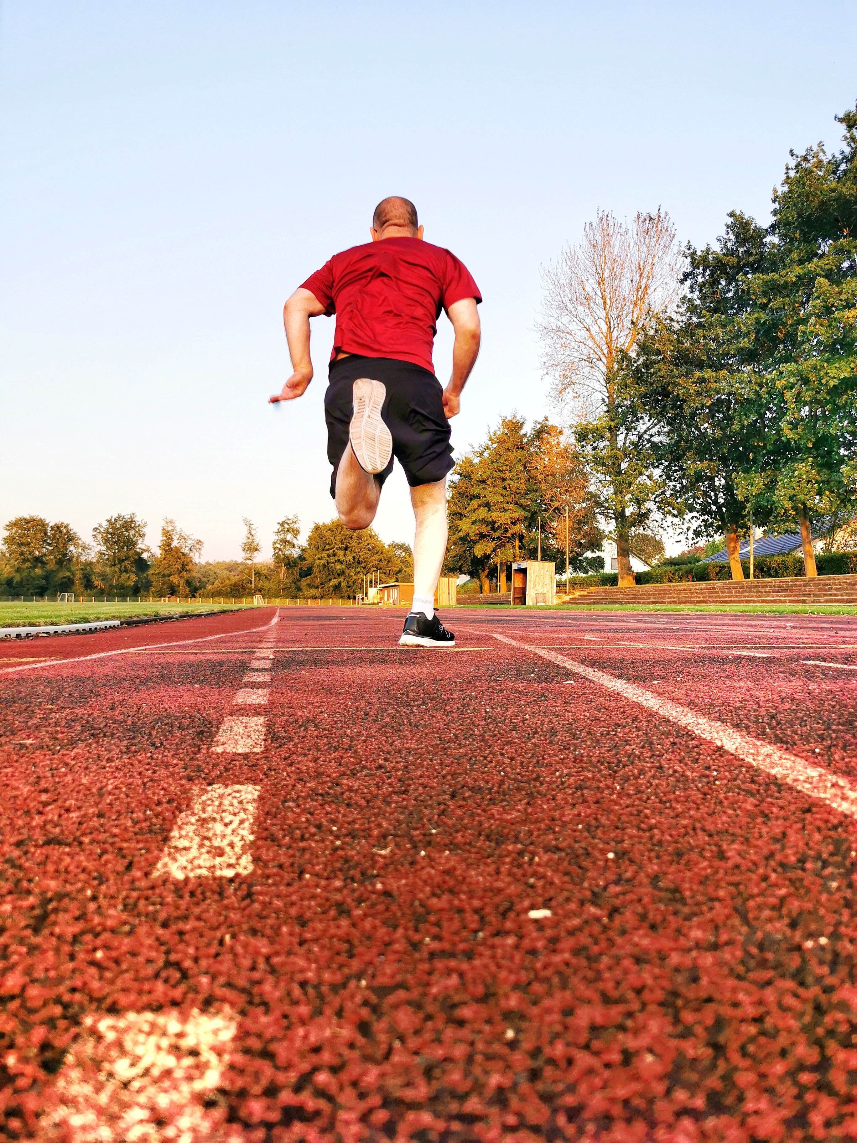 Atleta Corriendo En Pista Al Aire Libre En Verano · Foto de stock gratuita
