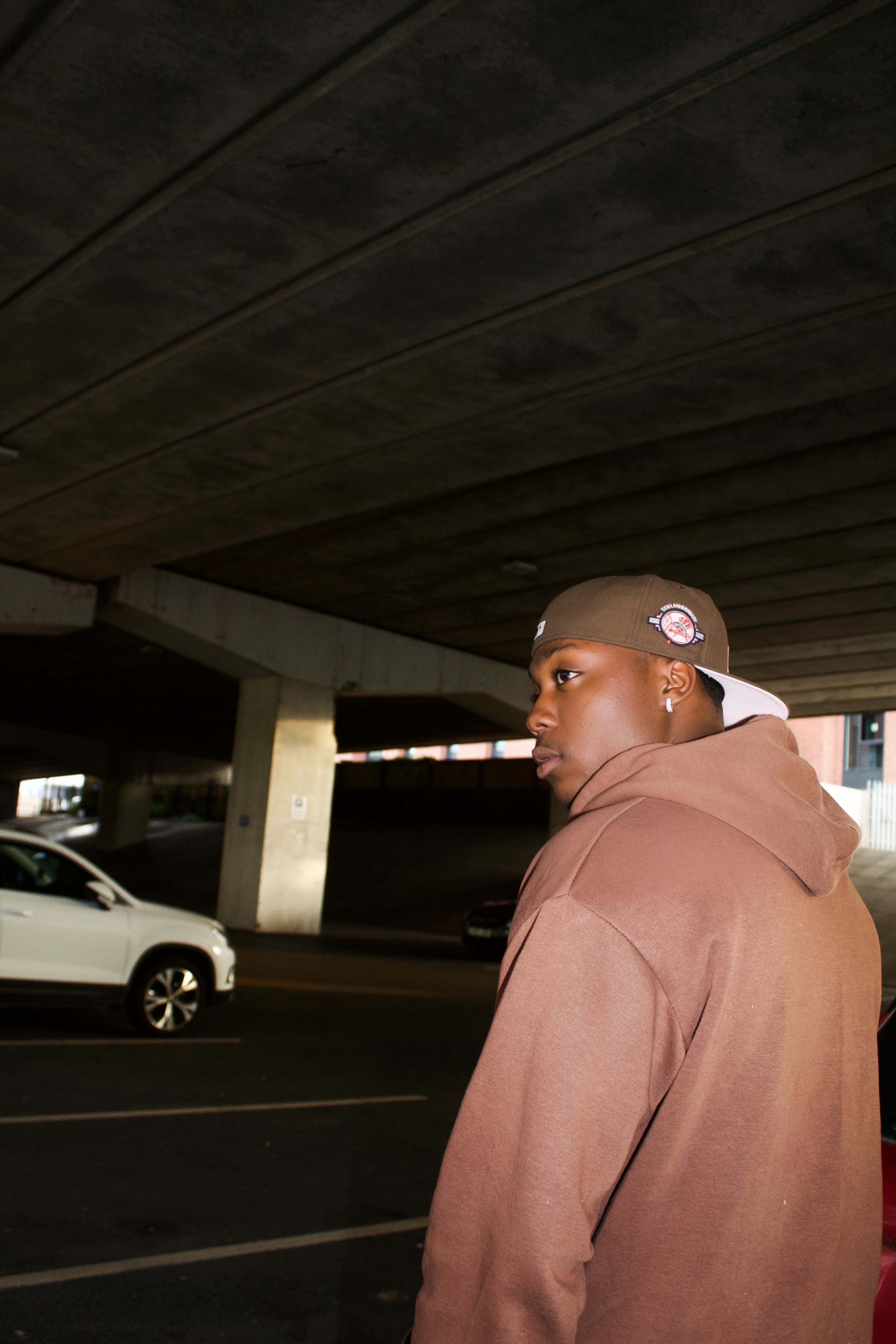 Young man in casual wear standing in an urban parking lot.