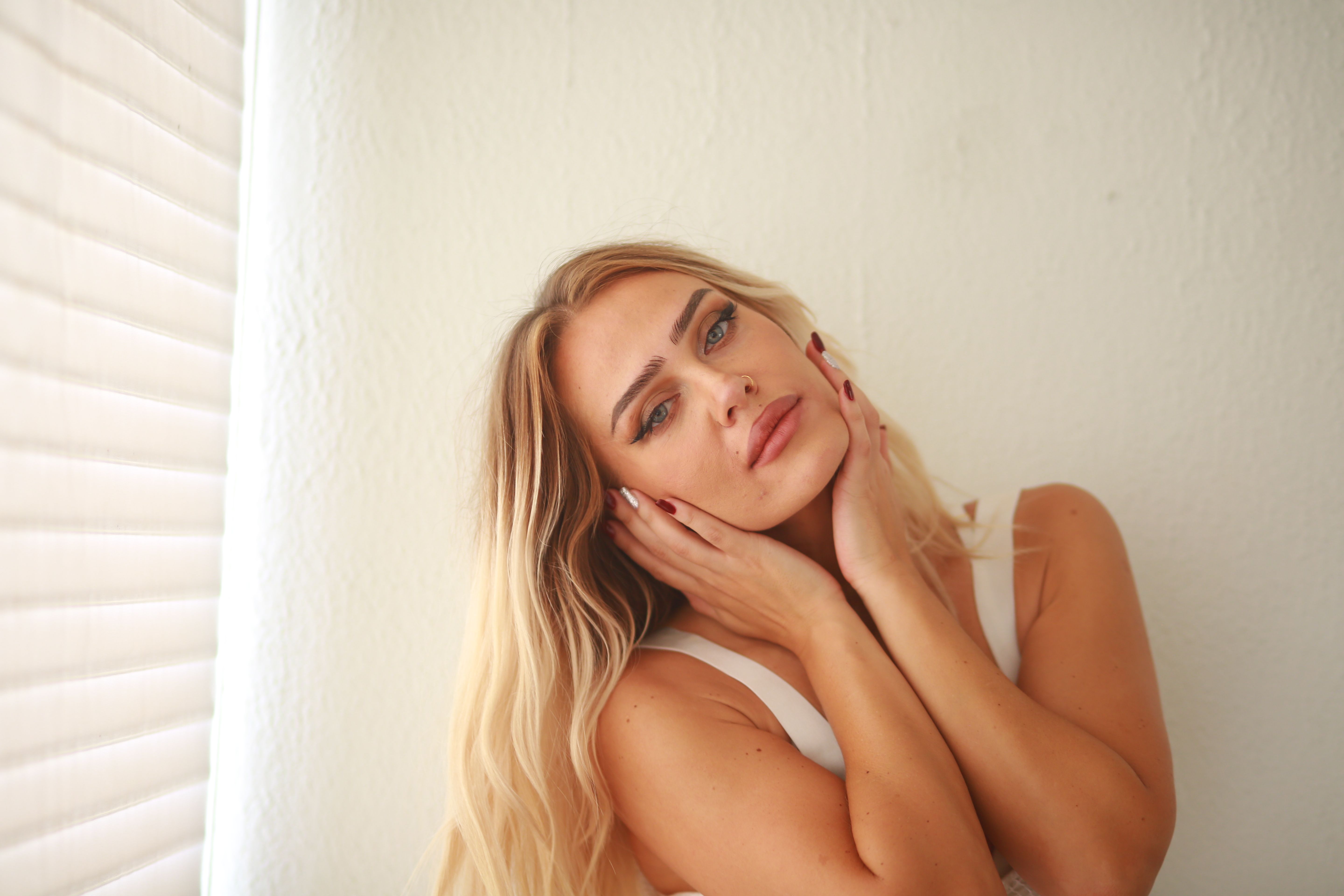 Elegant Woman Posing Indoors in Natural Light · Free Stock Photo