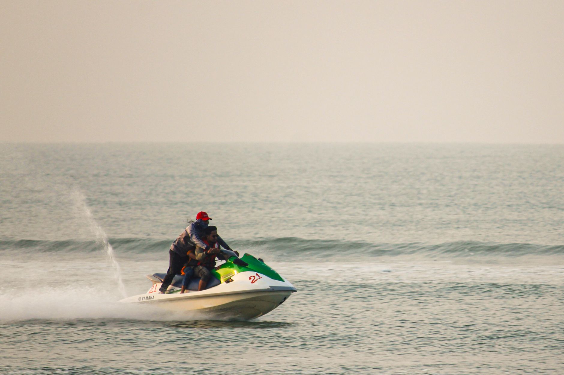 Des gens profitent d'une balade palpitante en jet ski lors d'une journée calme au bord de l'océan. - illustration
