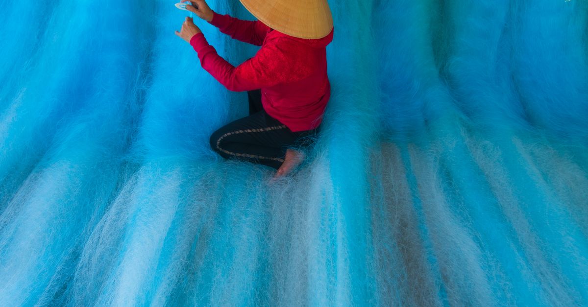Fisherman Weaving Nets in Vibrant Blue Environment · Free Stock Photo