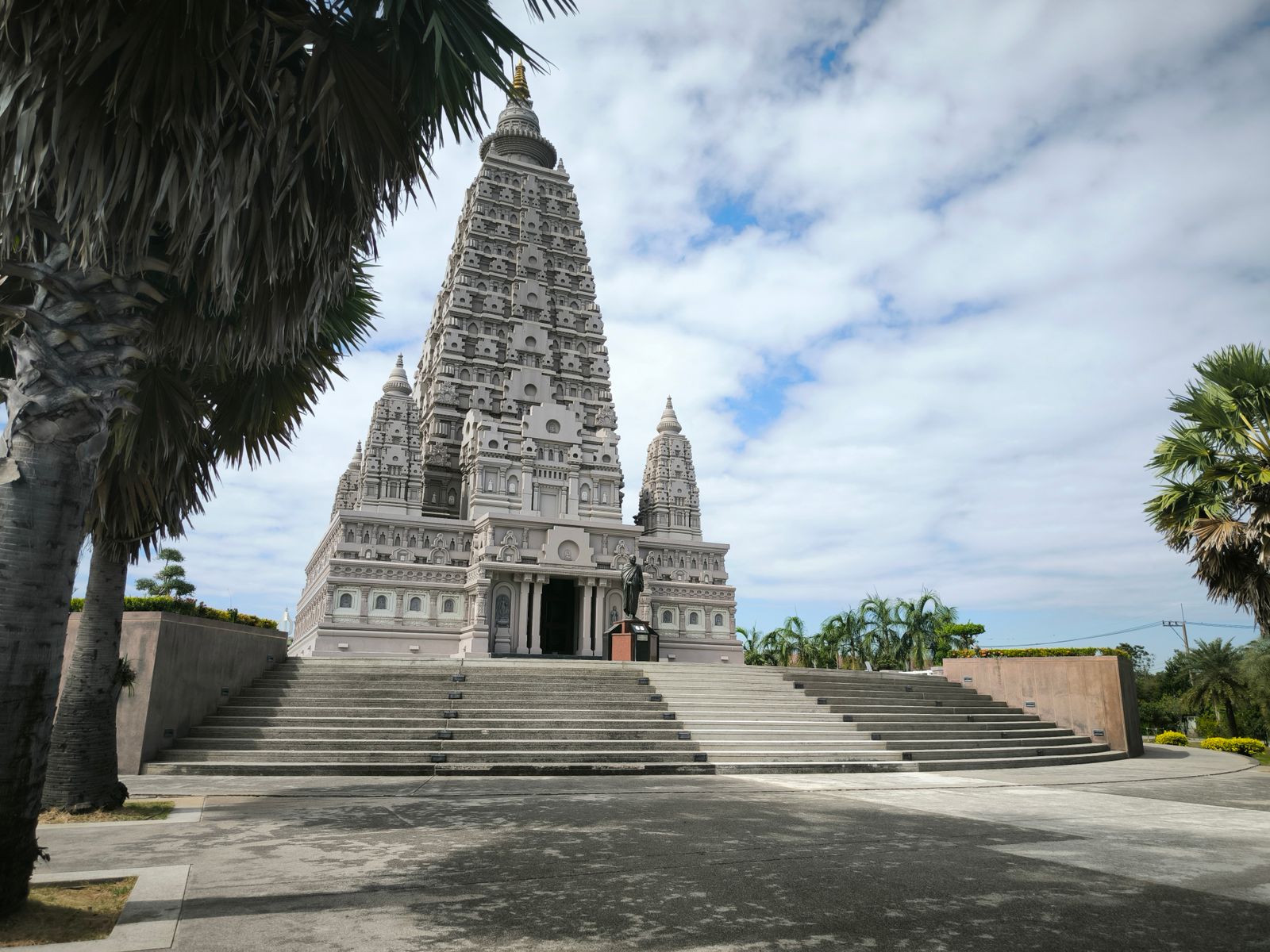 Stunning view of Mahabodhi Temple replica under clear skies in Pathum Thani, Thailand.