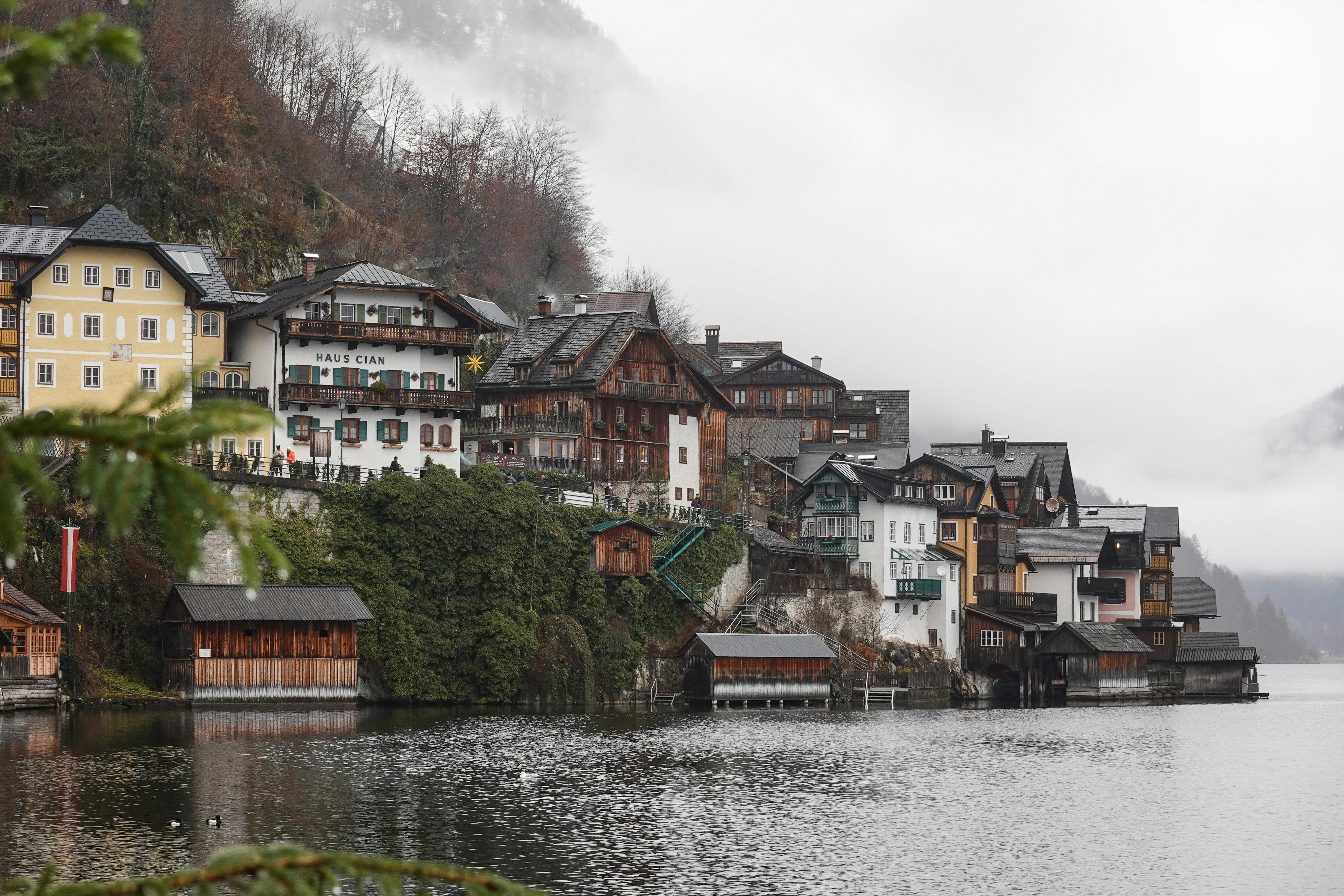 Charming mountain village with traditional huts and lake view shrouded in winter mist.