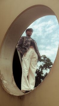 Stylish portrait of a person in modern urban architecture setting with circular window.