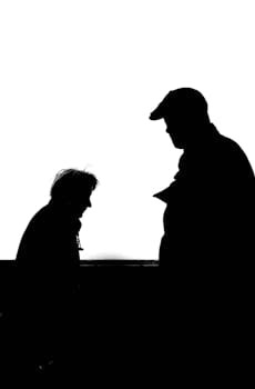High contrast silhouette photo capturing two adults conversing against a white background.
