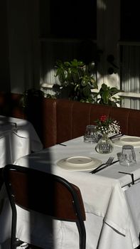 A beautifully set dining table in a sunlit outdoor terrace, perfect for a serene meal.