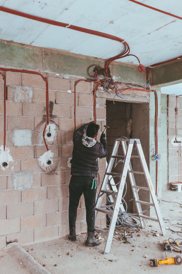 Electrician installing wiring during building renovation