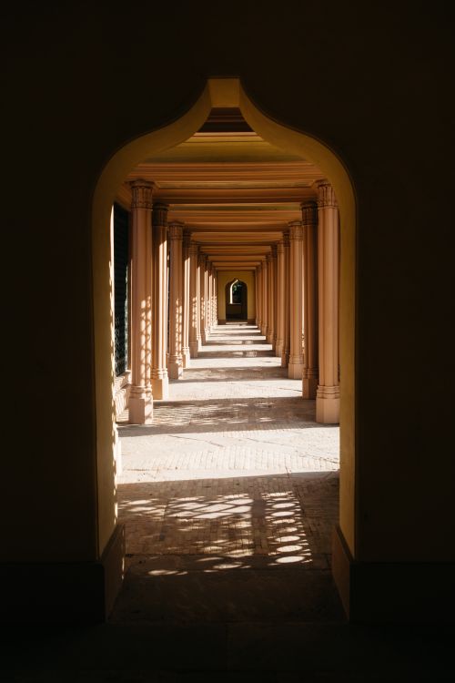 Free Elegant corridor at Schwetzingen Palace with stunning symmetry and light play, showcasing classic architecture. Stock Photo