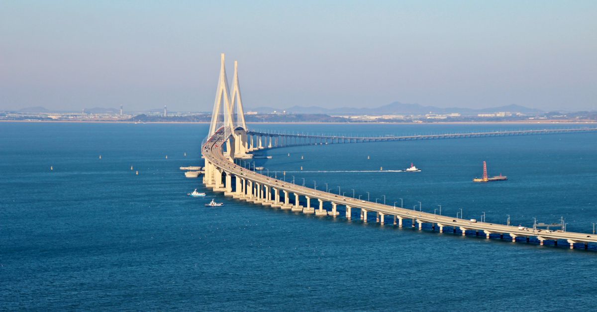 Stunning aerial view of Incheon Bridge spanning across blue ocean waters under a clear sky.