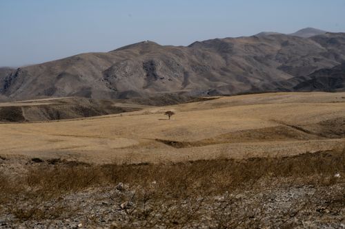 Free Expansive desert landscape with rolling hills and sparse vegetation in Mashhad, Iran. Stock Photo