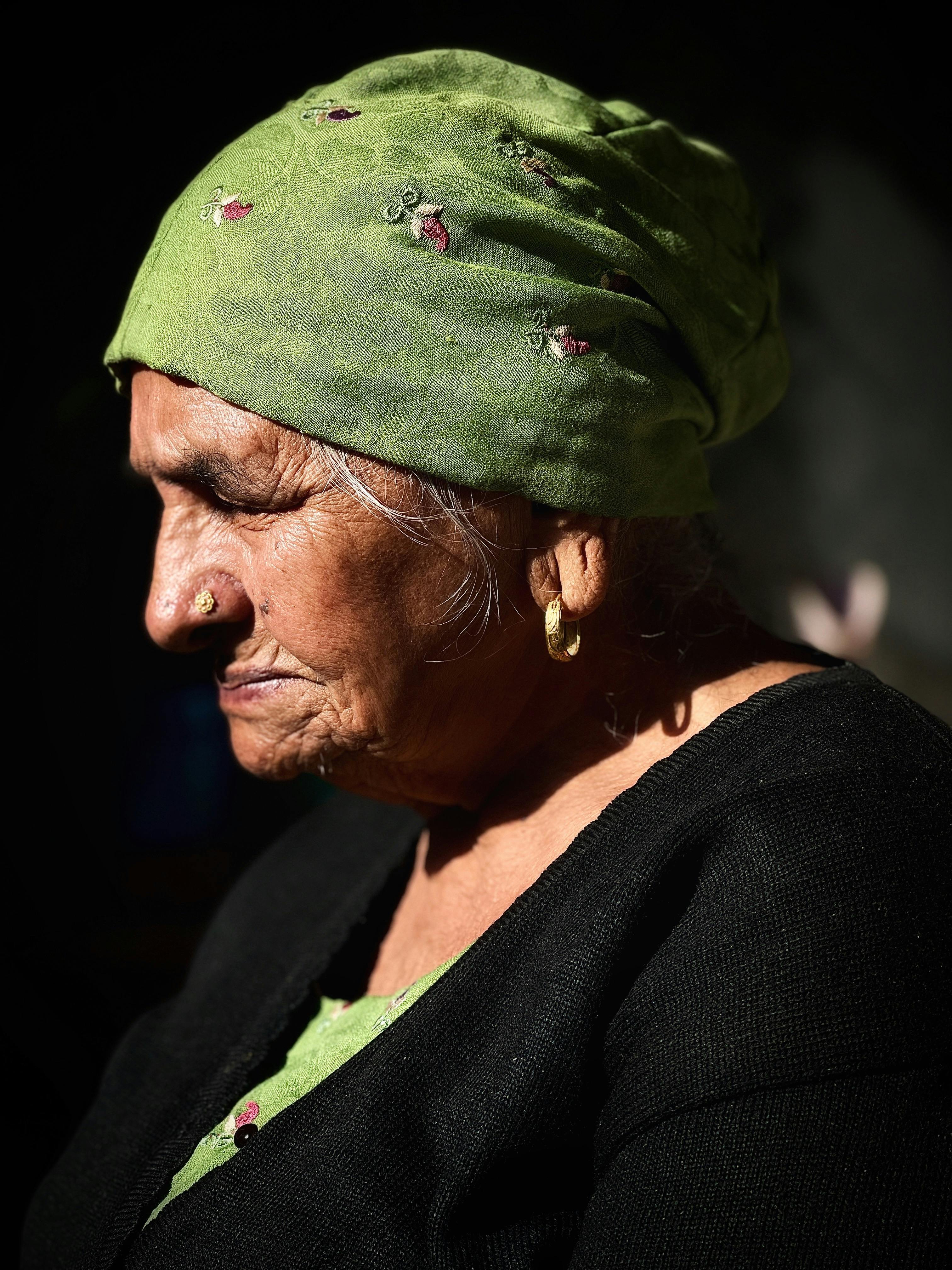 Close-up portrait of an elderly woman with green headscarf. Capturing timeless beauty and wisdom.