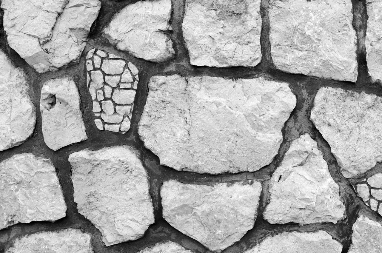 close up of a black and white textured stone wall with irregular shape