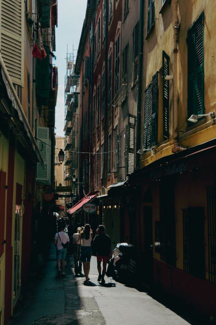 Wandering through a charming narrow street with colorful buildings in Old Town Nice, France.