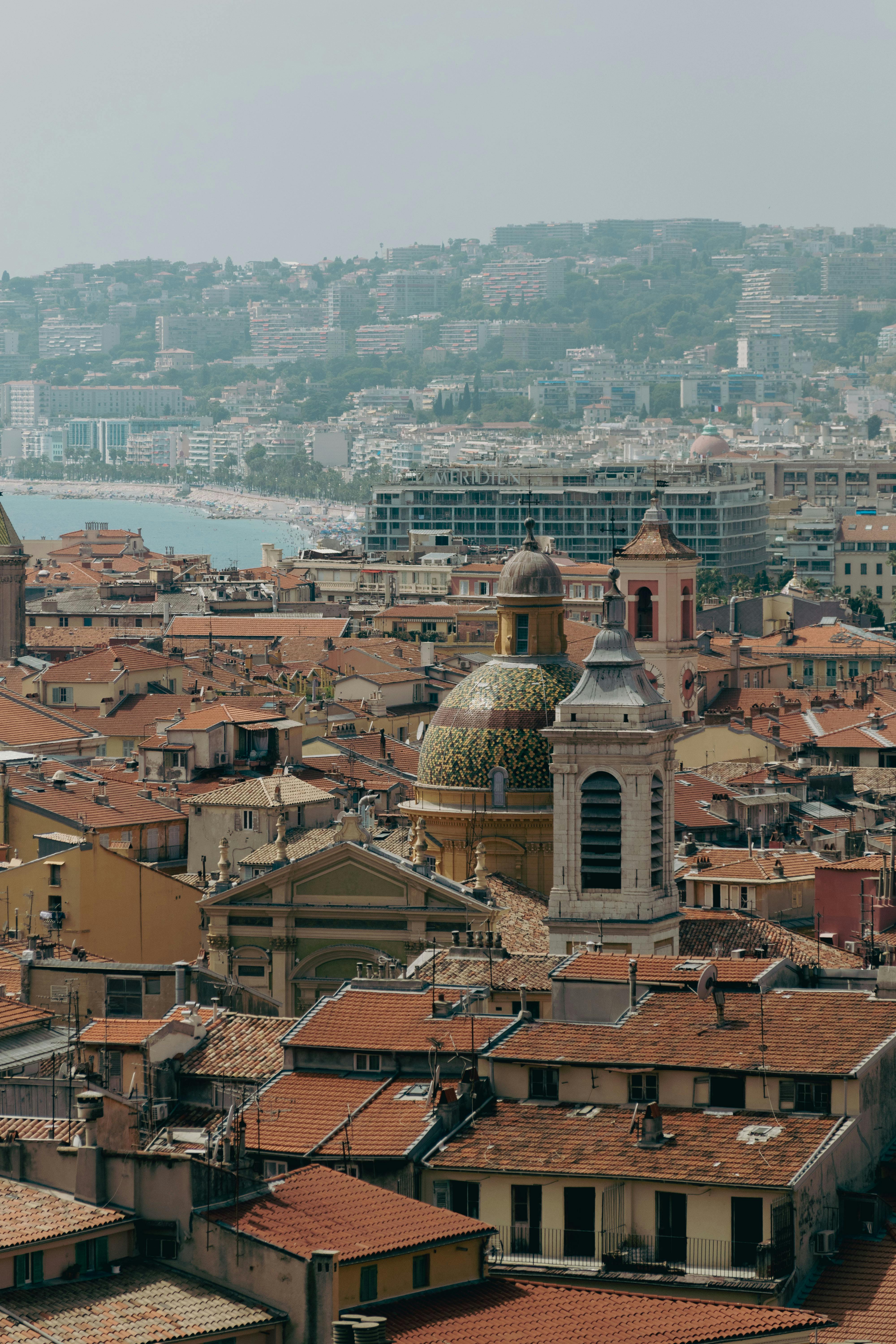 Discover the charming architecture of Nice, France with a panoramic view of its historic rooftops by the sea.
