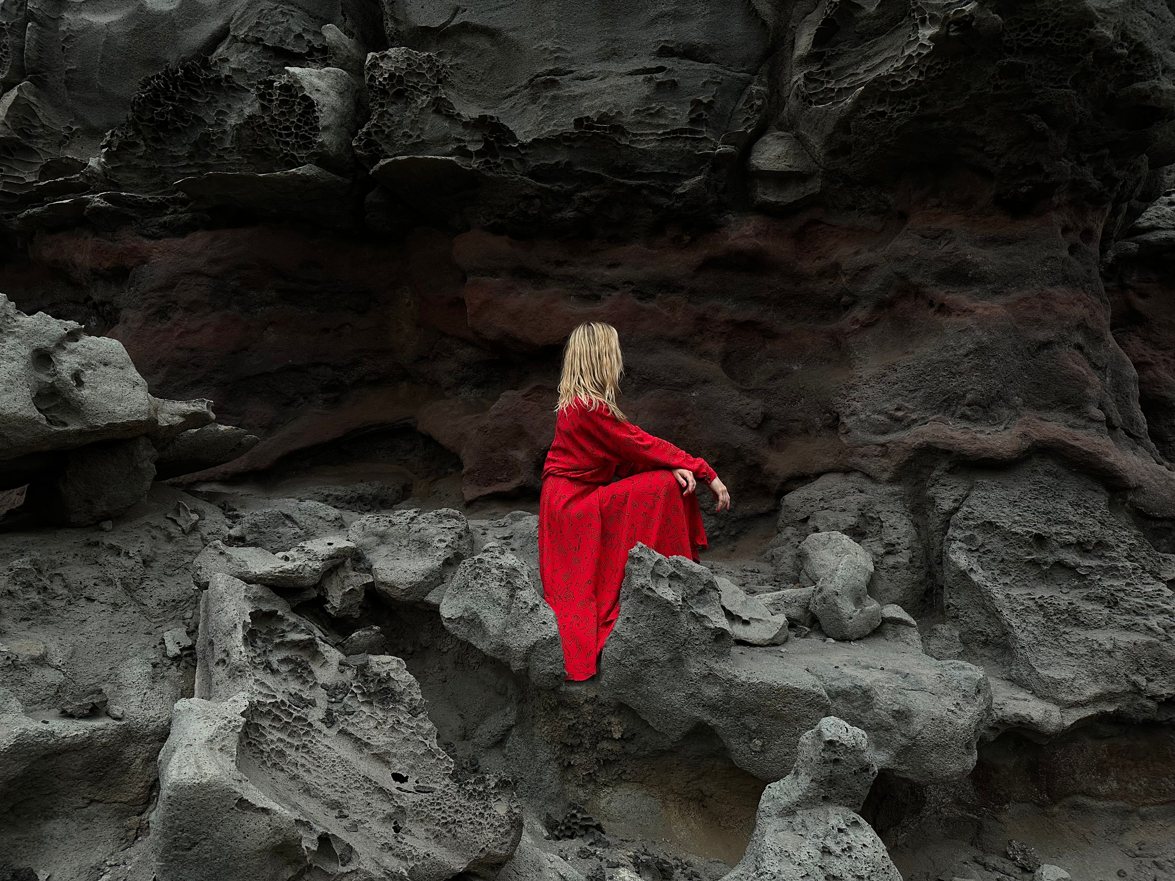 Woman in Red Dress on Rocky Cliff Background · Free Stock Photo