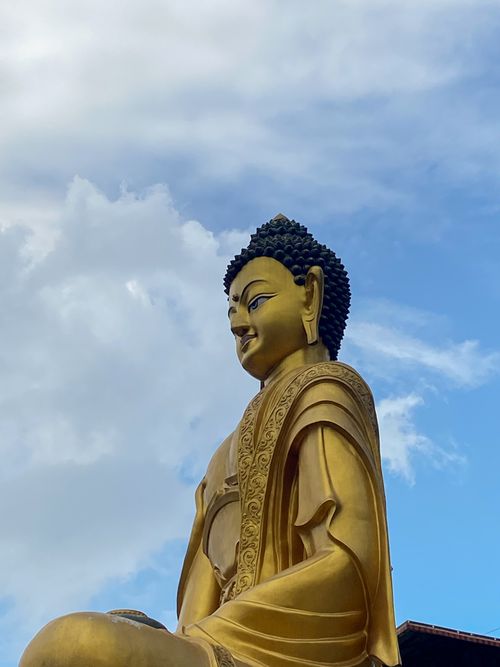 Free Golden Buddha statue in Darjeeling under a bright blue sky. Serene and majestic. Stock Photo