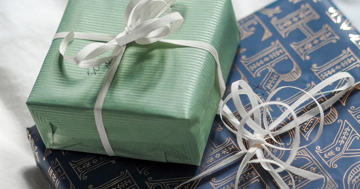 Elegantly wrapped anniversary gifts with ribbon on white linen