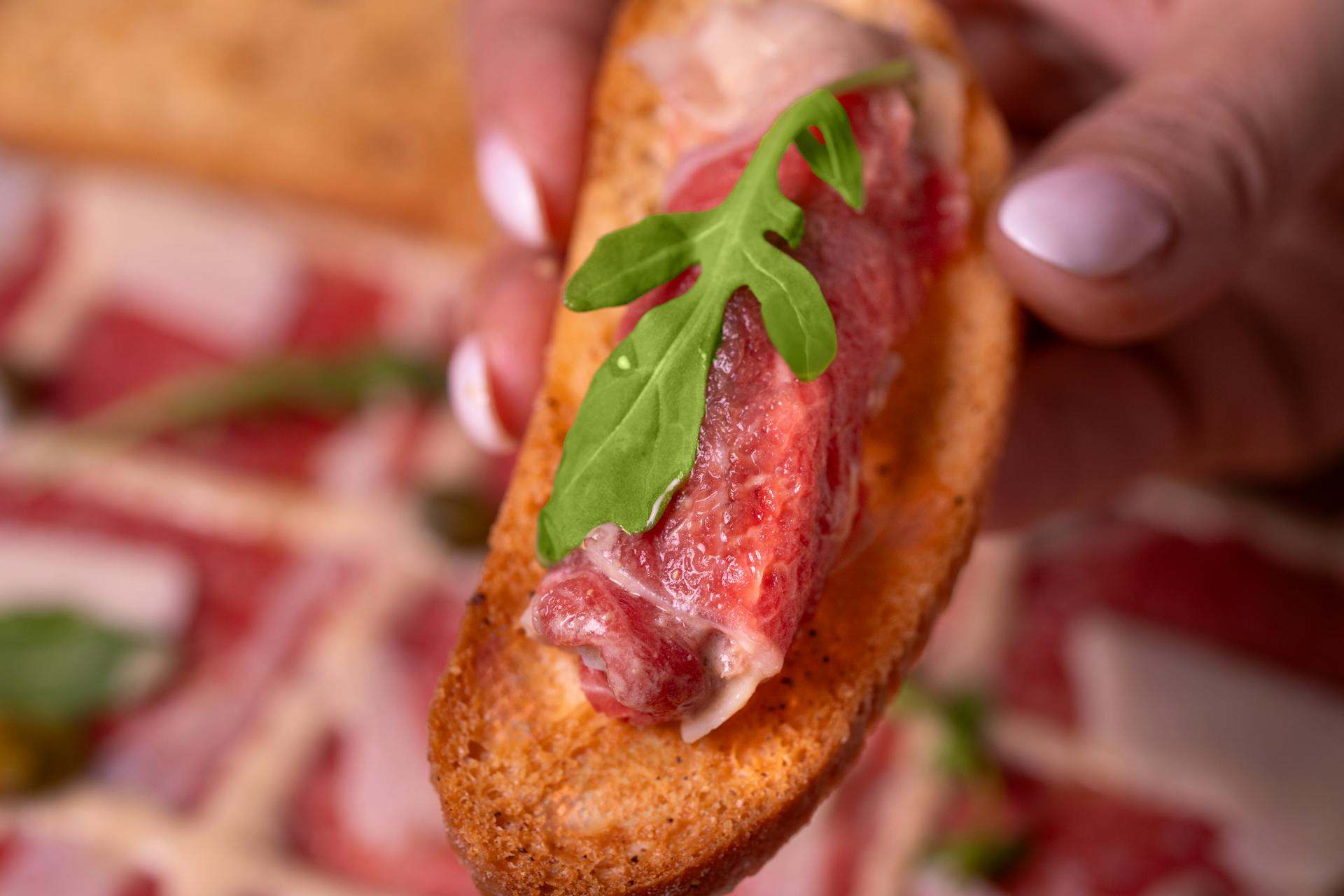 Delicious crostini topped with raw beef and arugula, perfect for gourmet appetizers.