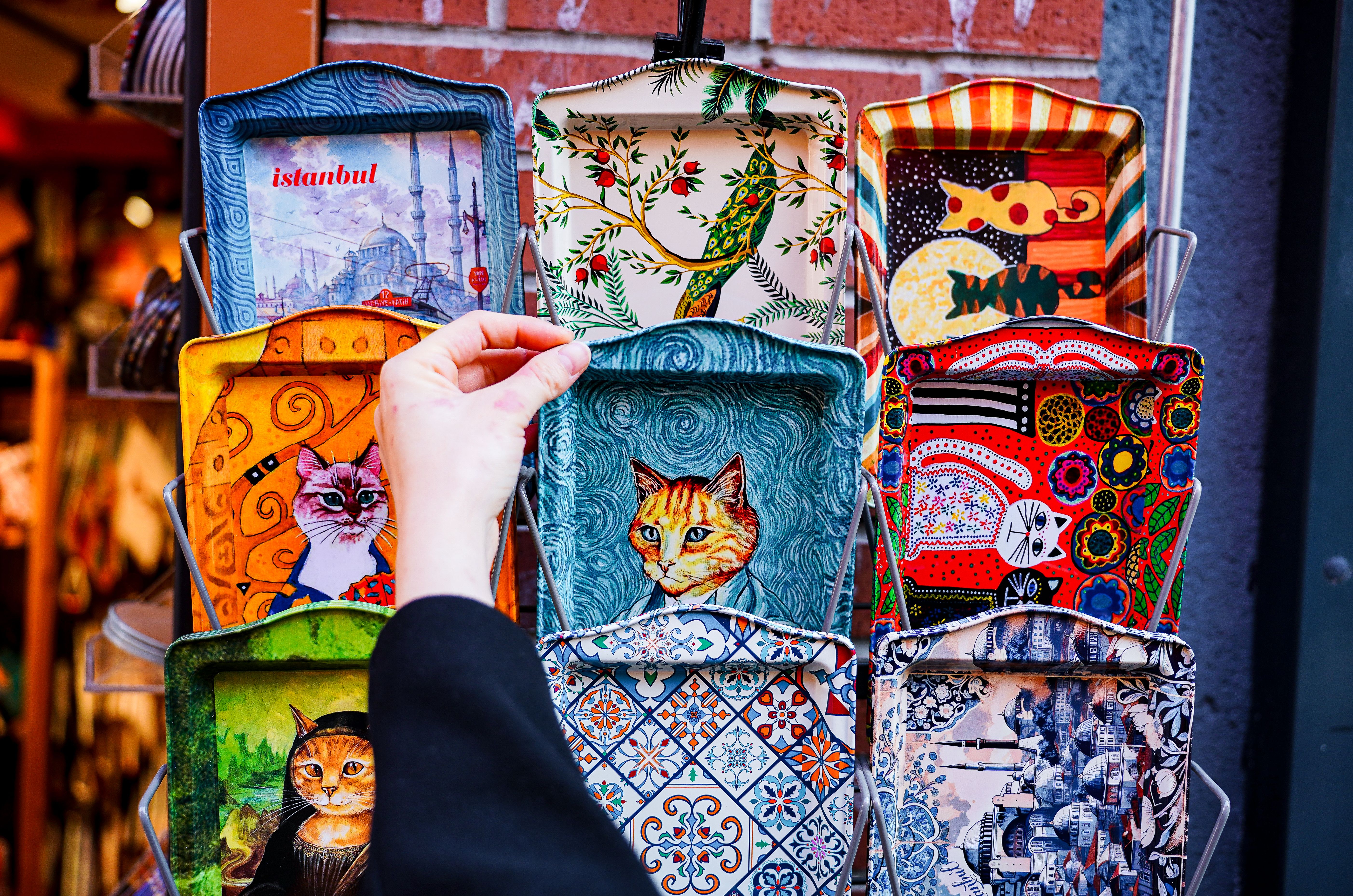 市場には、猫のデザインが施された芸術的なトルコのトレイが鮮やかに展示されています。