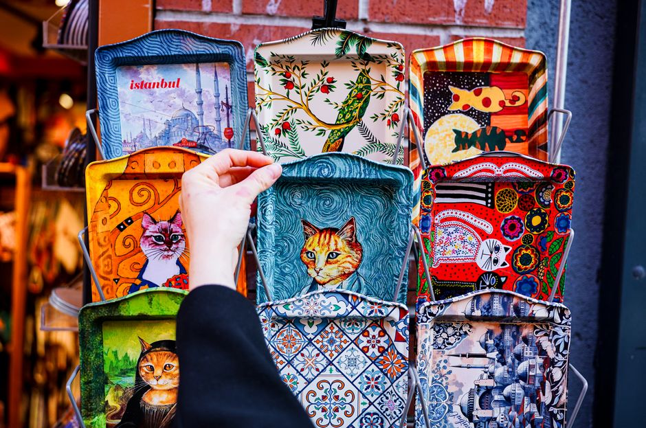 市場には、猫のデザインが施された芸術的なトルコのトレイが鮮やかに展示されています。
