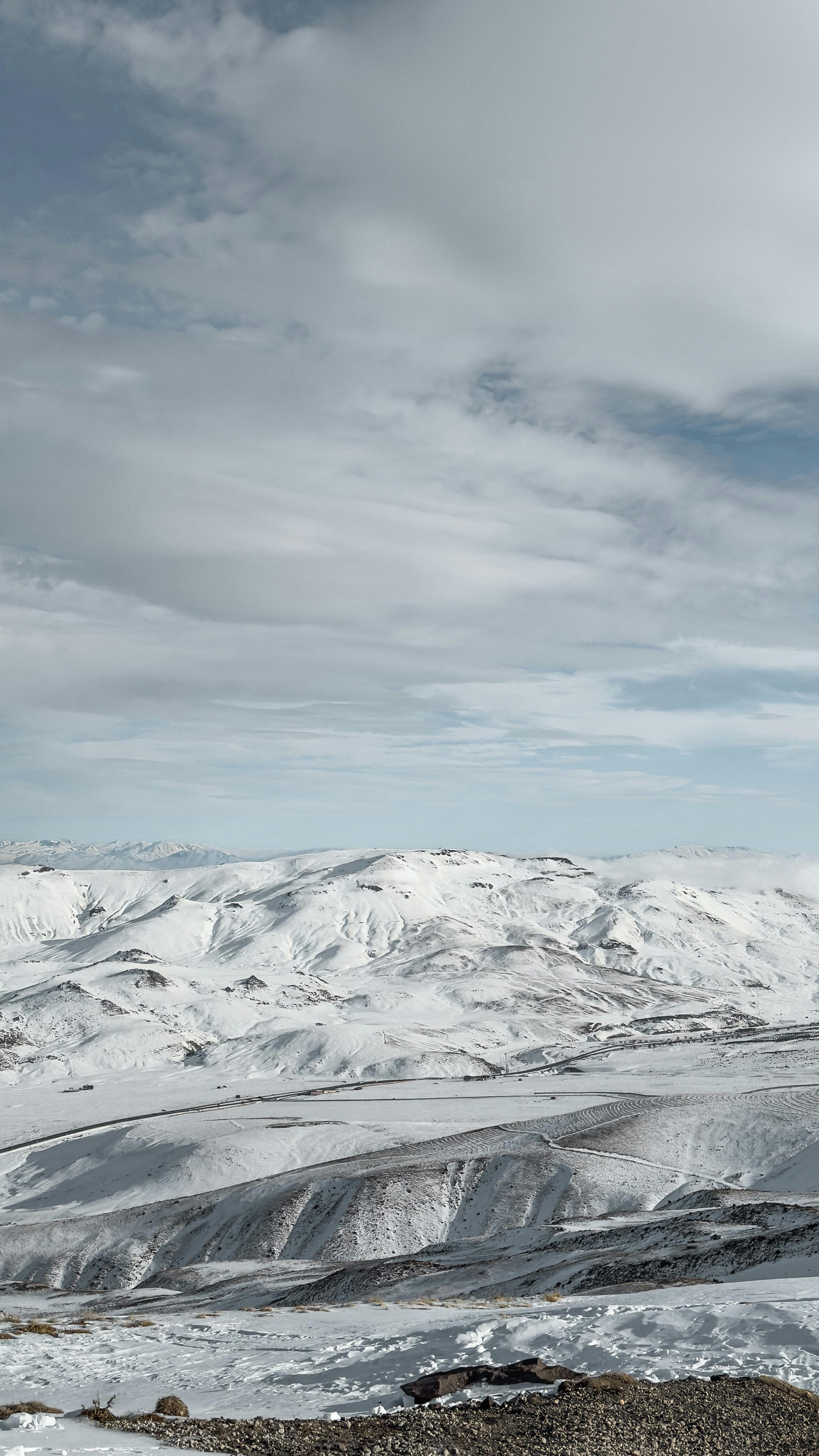 A scenic view of the snow-covered Erciyes mountains under a moody winter sky.