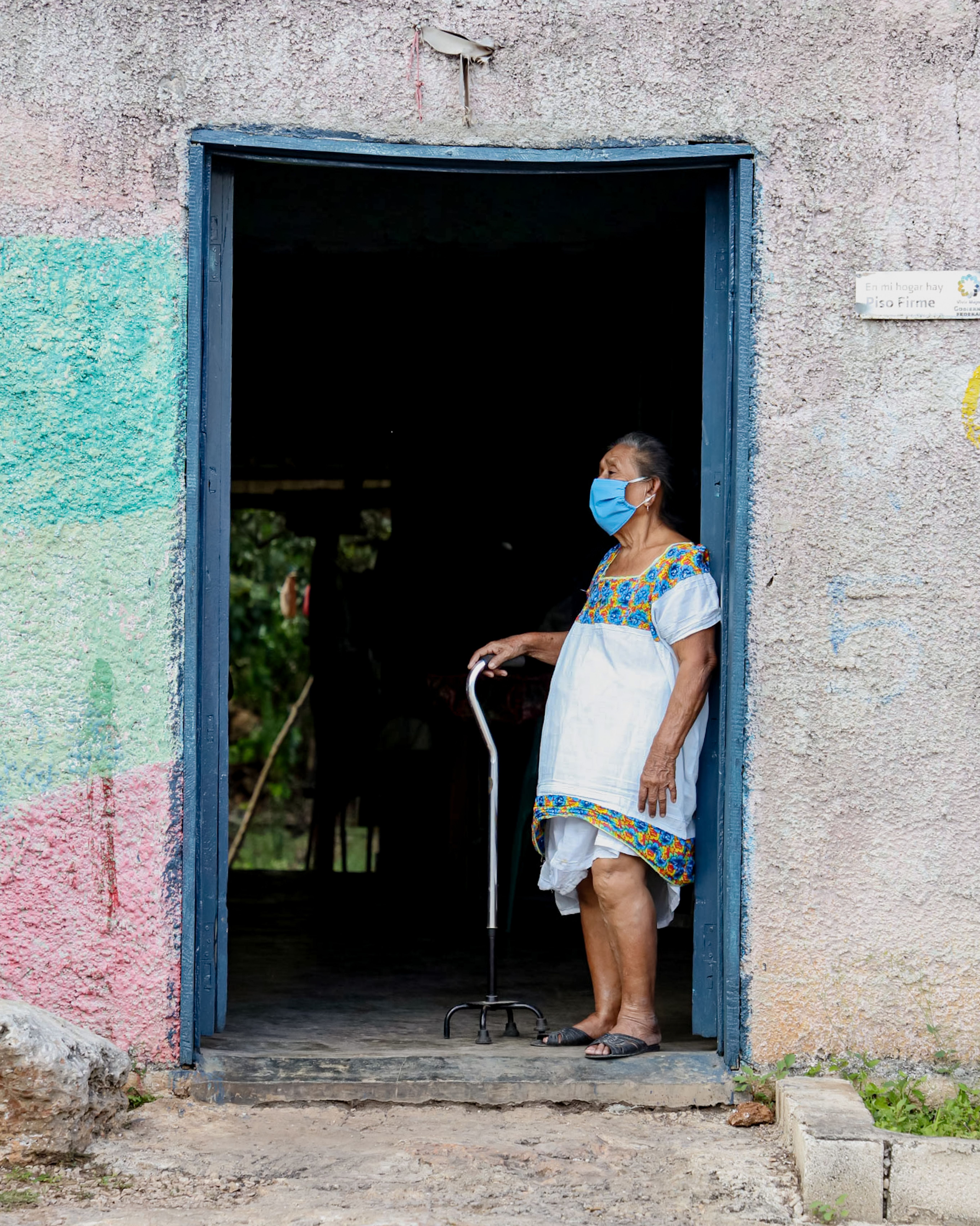 Elderly Woman in Traditional Dress at Doorway · Free Stock Photo