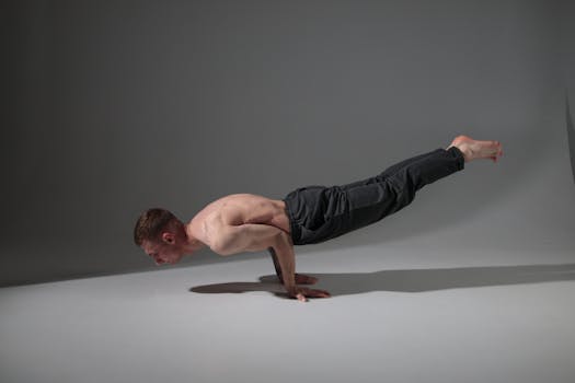 Man executing an advanced yoga pose, showcasing strength and balance indoors.