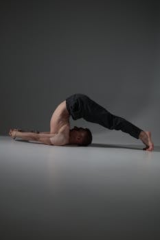A man performing an advanced yoga position indoors on a serene background.