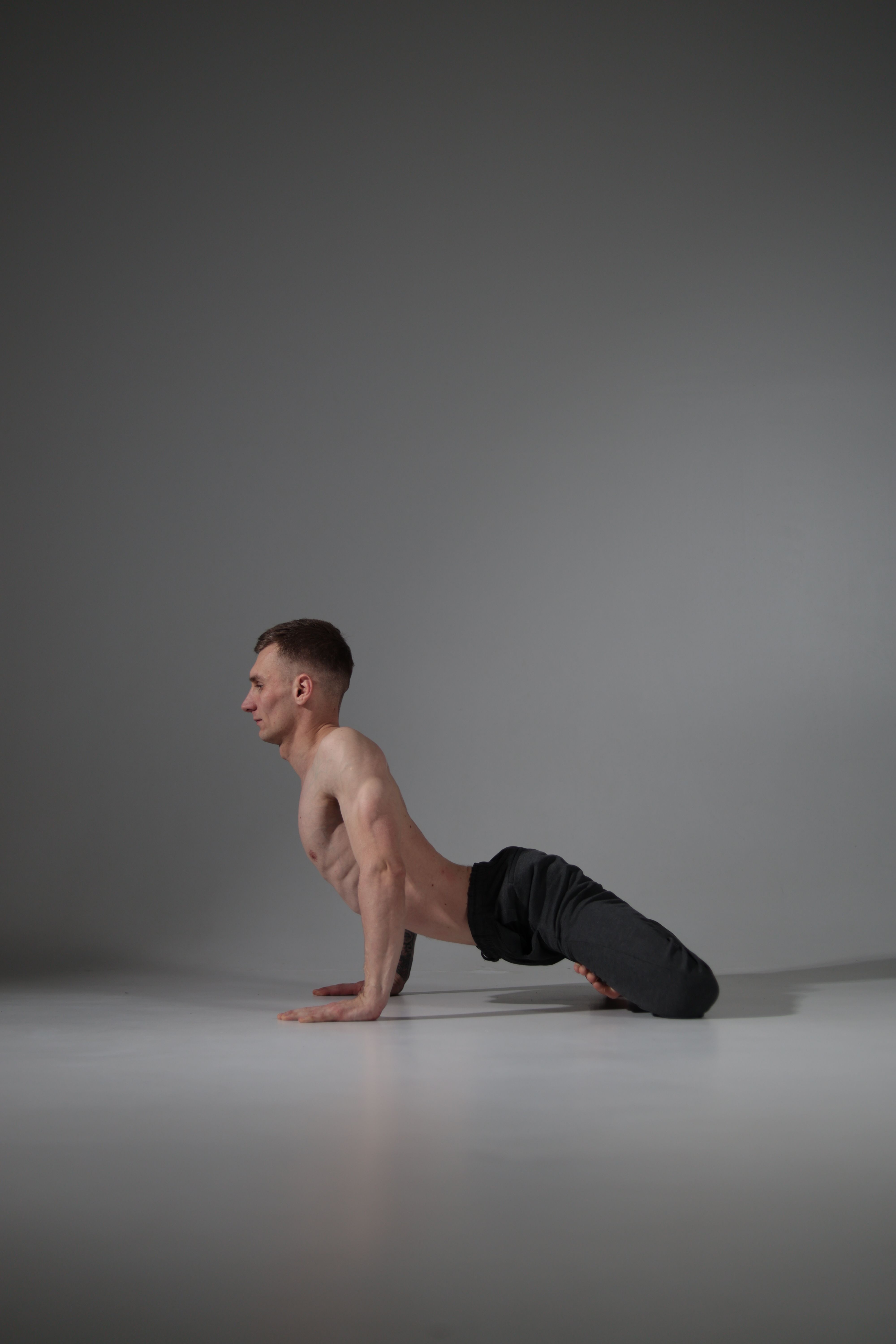 Man practicing a controlled yoga pose in a studio