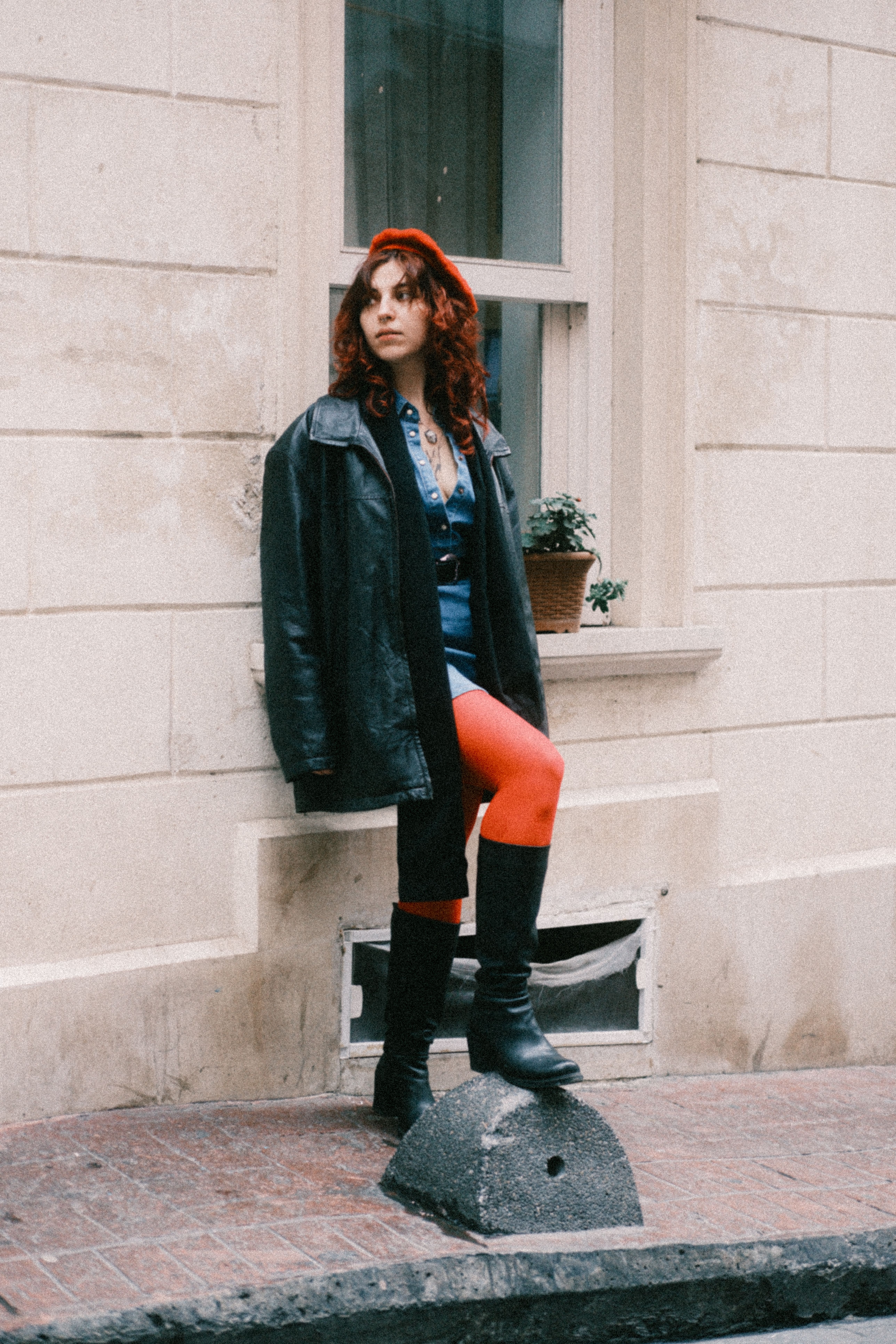 Stylish woman in leather jacket in urban setting, creative office outfit