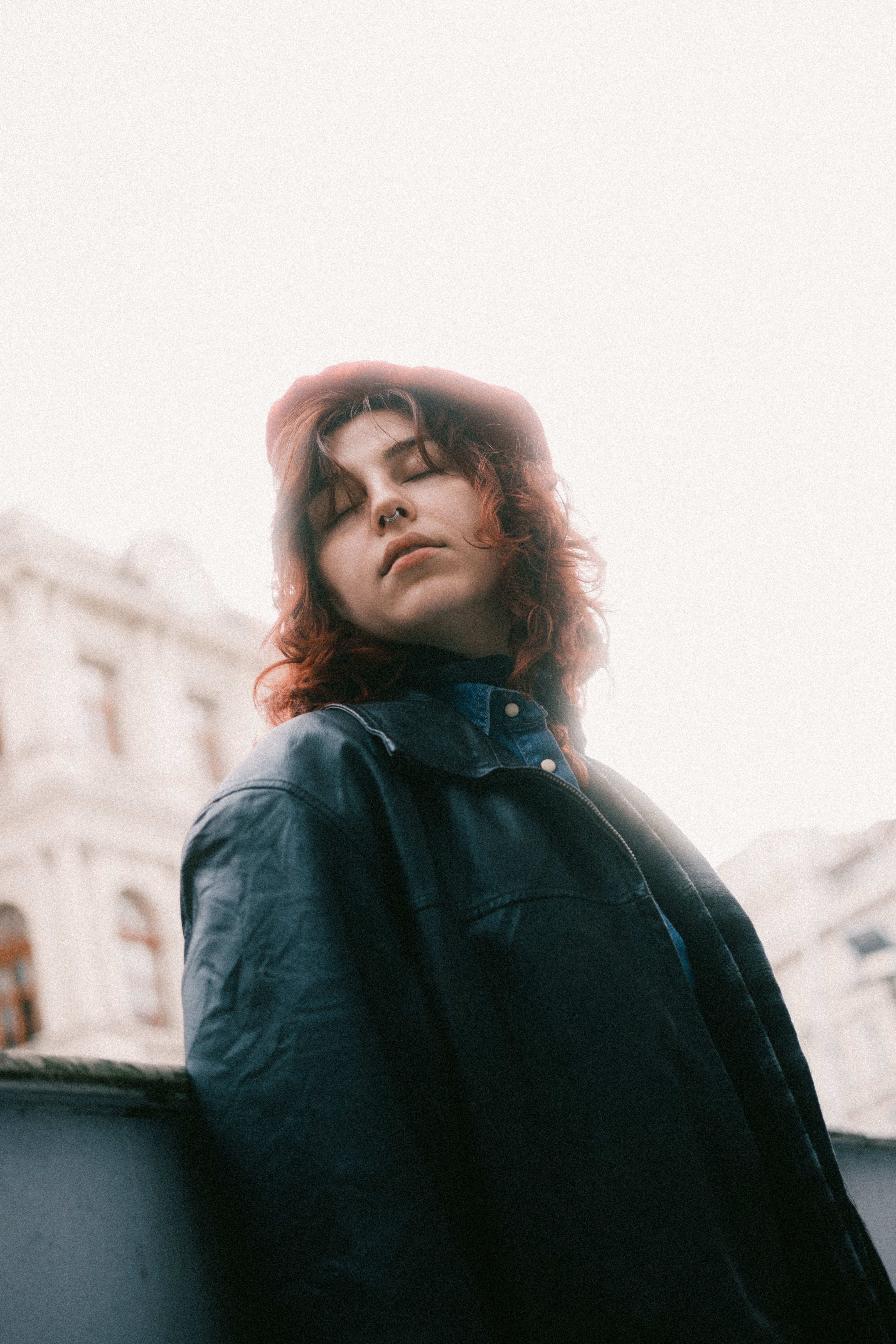 Woman wearing beret and leather jacket outdoors
