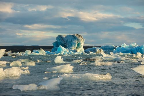 Free Glistening iceberg in frozen waters under a serene sky, showcasing natural beauty. Stock Photo