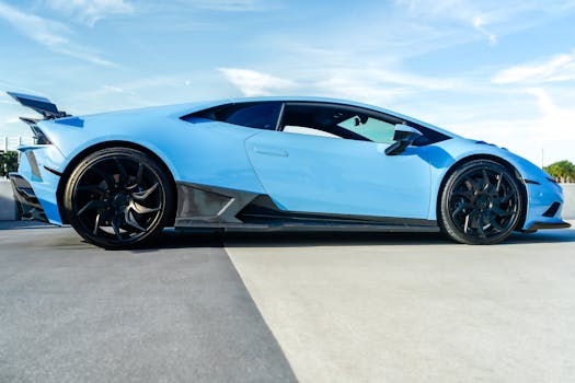 A stylish blue sports car parked outdoors under a clear sky, showcasing modern design.