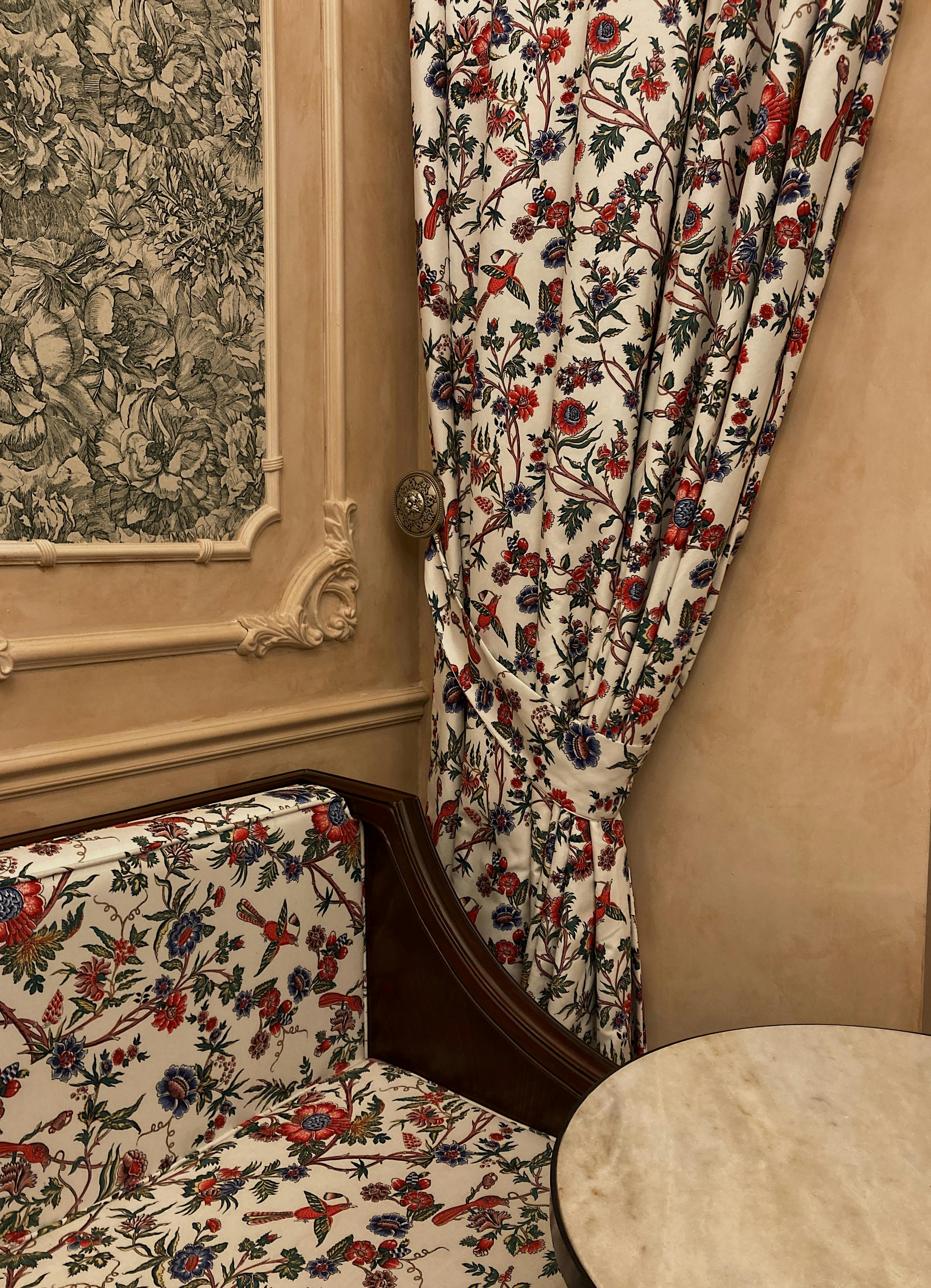 Elegant room featuring floral curtains, vintage wallpaper, and a classic sofa for a soothing ambiance.