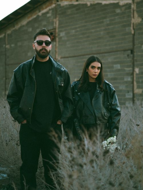 Free Stylish couple wearing leather jackets posing in an urban environment. Moody and fashionable. Stock Photo