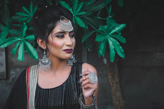 Portrait of an elegant Indian woman wearing traditional jewelry and attire outdoors.
