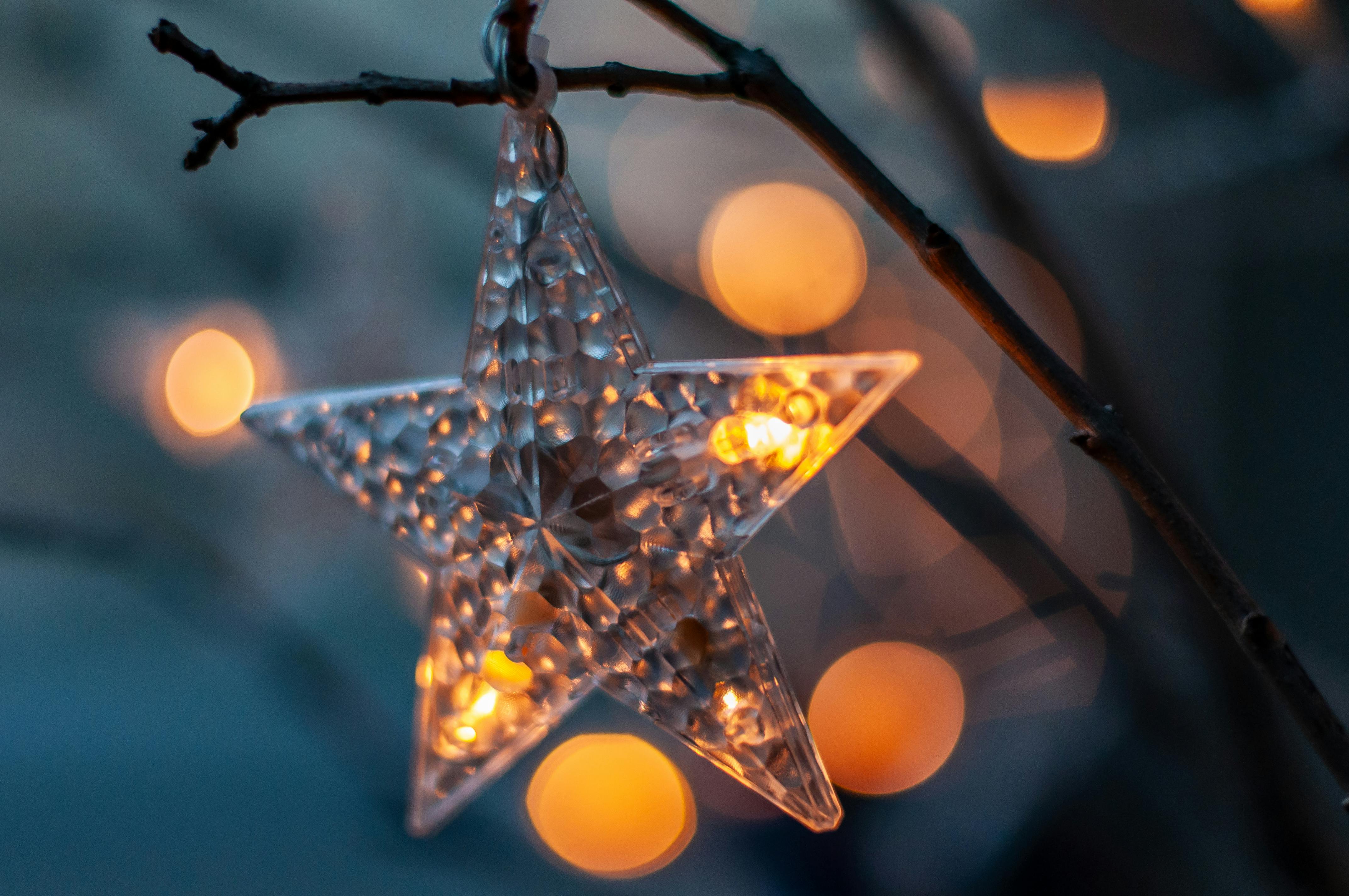 Δωρεάν Κοντινό πλάνο ενός λαμπερού αστεριού στολίδι που κρέμεται σε ένα κλαδί, με απαλά φώτα bokeh. Φωτογραφία από στοκ φωτογραφιών