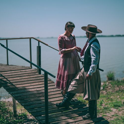 Free A traditional gaucho couple in period attire share a moment by the riverside in Chascomús, Argentina. Stock Photo