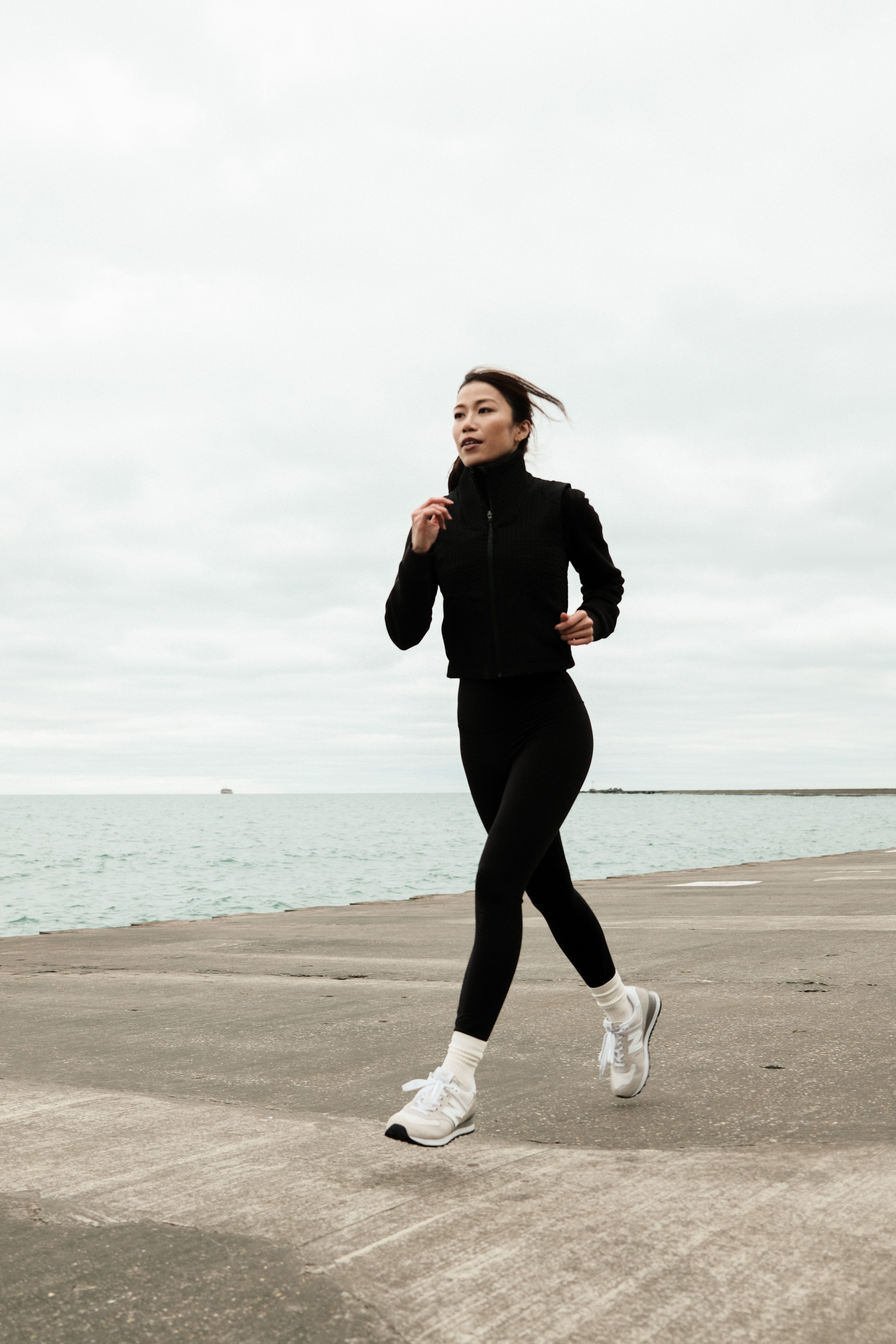 Mujer haciendo jogging junto al paseo maritimo